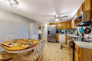 a kitchen with a table and a refrigerator at Serene home with a deck, grill, firepit, board games, washer/dryer, & mtn views in East Lamoine +13 photos