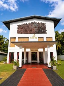 a building with a sign on the front of it at Amore Beach Resort in Balapitiya