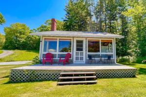 a gazebo with red chairs and a table at Classic home overlooking the St George River with deck & great views in Saint George