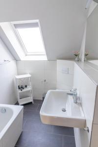 a white bathroom with a sink and a skylight at Melanie in Lenz