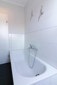 a white bath tub with a shower in a bathroom at Melanie in Lenz