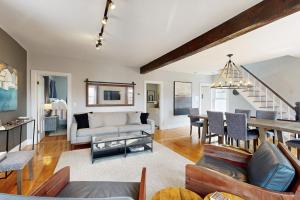 a living room with a couch and a table at Charming, historic cottage with modern upgrades - stroll to dining & attractions in Boothbay Harbor