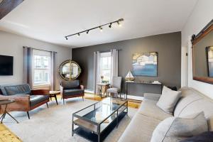 a living room with a couch and a table at Charming, historic cottage with modern upgrades - stroll to dining & attractions in Boothbay Harbor