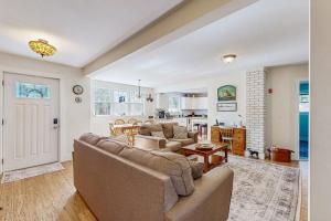 a living room with a couch and a kitchen at Coastal bungalow with large yard, beautiful kitchen, & great location in Boothbay Harbor