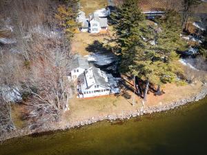 an aerial view of a large house with trees at Cobbossee Hideaway, lakefront property with dock for swimming, fishing, and sunrises in Winthrop +8 photos