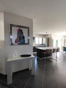 a living room with a table and a painting of a dog at Villa Melloco in Varilhes