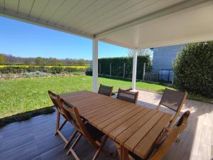a wooden table and chairs on a patio at Villa Melloco in Varilhes