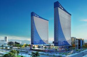 two tall buildings in a city with palm trees at Royal Sea View Batumi in Batumi