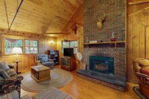 a living room with a fireplace in a cabin at Lakefront Home with Private Dock, Pebble Beach & Enclosed Porch - Dogs Welcome in Greenville Junction
