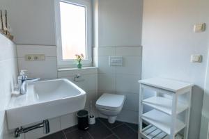 a white bathroom with a sink and a toilet at Monique in Lenz