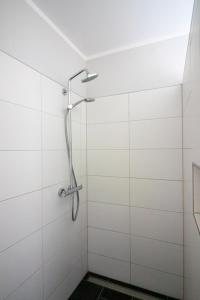 a shower in a bathroom with white tiles at Monique in Lenz