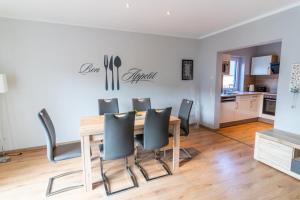 a dining room table with chairs and a kitchen at Monique in Lenz