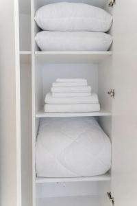 a closet filled with white pillows and towels at Royal Sea View Batumi in Batumi +21 photos