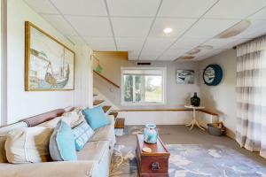 a living room with a couch and a table at Oceanfront home with dock, beautiful deck & firepit - steps to the beach in Harpswell Center