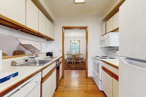 a kitchen with white appliances and a dining room at Townhome w/ Bonus Loft, High-Speed WiFi, Partial AC & Full Kitchen in Bar Harbor