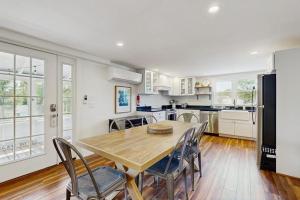 a kitchen with a wooden table and chairs in a room at Coastal charmer with screened-in porch, grill, & AC in Boothbay Harbor
