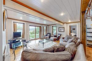 a living room with a couch and a tv at Lakefront home with outdoor firepit & private dock - near downtown in Greenville +44 photos