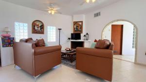 a living room with two chairs and a fireplace at Recently Renovated Oceanview Home Casa Hebe in Puerto Peñasco