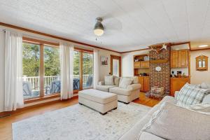 a living room with two couches and a table and chairs at Secluded waterfront home with private dock, outdoor dining, firepit, WiFi & W/D in Orland +35 photos