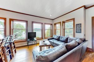 a living room with a couch and a television at Lakefront home with outdoor firepit & private dock - near downtown in Greenville