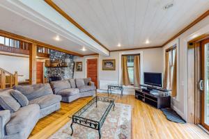 a living room with a couch and a tv at Lakefront home with outdoor firepit & private dock - near downtown in Greenville