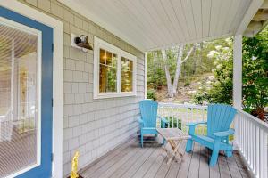 two blue chairs and a table on a porch at Periwinkle Cottage | Sunny cottage in Westport Island overlooking the river in Westport
