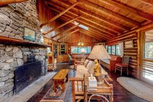 a living room with a stone fireplace in a log cabin at Stunning log cabin with fireplace & nature views - near shopping & dining in Boothbay Harbor +20 photos