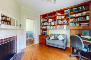 a living room with a chair and a desk with a computer at Parker House: Historic home - walk downtown, dog-friendly & washer/dryer in Camden