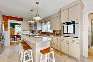 a kitchen with white cabinets and a large island at Coastal Serenity Retreat with Ocean Views, Spacious Porch and Modern Comforts in Sullivan +19 photos