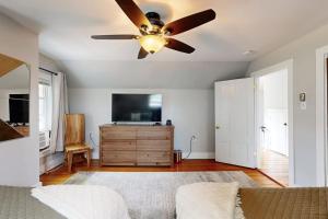 a living room with a ceiling fan and a television at Charming, historic cottage with modern upgrades - stroll to dining & attractions in Boothbay Harbor +20 photos