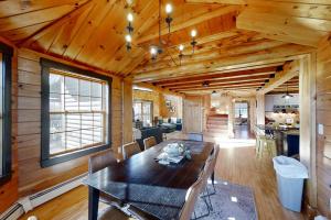 a dining room and living room with a wooden ceiling at Stunning & Spacious Log Cabin in the Woods in Boothbay Harbor +33 photos