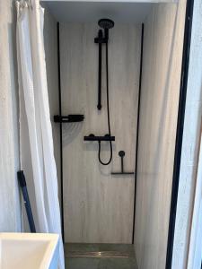 a shower in a bathroom with a shower curtain at Barefoot Cottage in Noordwijk +7 photos