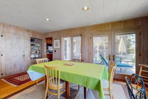 a dining room with a green table and chairs at Beachfront Delight with detached guesthouse, private beach access, Dog-friendly in Southport