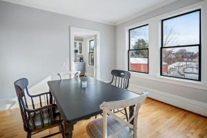 a dining room with a black table and chairs at Waterfront, walkable, updated home with harbor views & partial AC in Camden