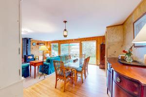 a dining room and living room with a table and chairs at Dog-friendly 3-story home with wood stove, deck, grill, ocean views, W/D, AC in Southwest Harbor