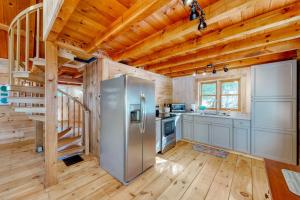 a kitchen with a stainless steel refrigerator and a staircase at Cozy woodsy Cabin w/ a Deck, Firepit, Gas Grill, Free WiFi, & Full Kitchen in Greenville
