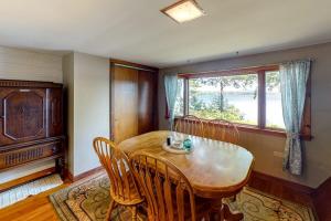 a dining room with a table and chairs and a window at Waterfront A-frame on George's Pond with views, private dock, beach, kayaks, SUP in Franklin