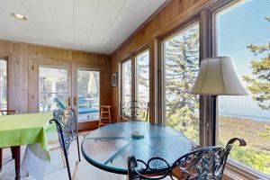 a dining room with a table and some windows at Beachfront Delight with detached guesthouse, private beach access, Dog-friendly in Southport