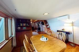 a dining room with a wooden table and chairs at Waterfront A-frame on George's Pond with views, private dock, beach, kayaks, SUP in Franklin +15 photos