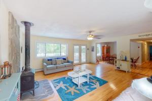 a living room with a couch and a stove at Waterfront home with deck, patio, grill, firepit, Ping-Pong, & WiFi in Somesville