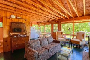 a living room with a couch and chairs in a cabin at Classic home overlooking the St George River with deck & great views in Saint George