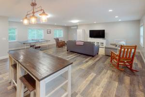 a living room with a couch and a table at Waterfront home with deck, patio, grill, firepit, Ping-Pong, & WiFi in Somesville