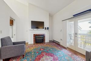 a living room with a fireplace and a tv at Bay View Dog-Friendly Townhouse w/Porch, Gas Grill, Washer/Dryer, Partial A/C in Bar Harbor