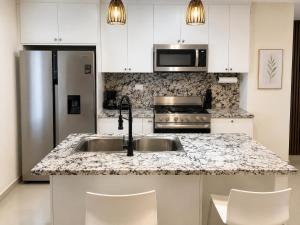 a kitchen with a sink and a refrigerator at Eco Avalon Paradise Villa in Punta Cana