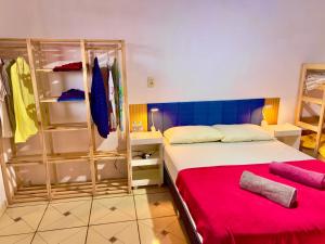 a bedroom with a bed with a red blanket at Reis Family Paraty - Suíte Privativa Nova e Funcional com Varanda in Paraty
