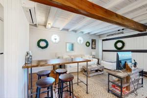 a living room with a table and some stools at Iconic downtown retreat with firepit & fireplace- walk to Harbor Footbridge in Boothbay Harbor