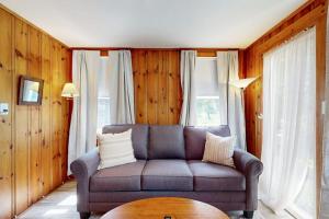 a living room with a couch and a table at Coastal Serenity Retreat with Ocean Views, Spacious Porch and Modern Comforts in Sullivan