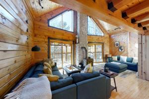 a living room with a blue couch in a log cabin at Stunning & Spacious Log Cabin in the Woods in Boothbay Harbor