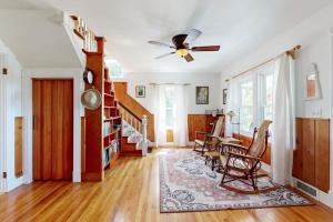 a living room with a ceiling fan and a table at Coastal Serenity Retreat with Ocean Views, Spacious Porch and Modern Comforts in Sullivan
