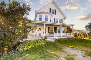 a white house with a porch and a yard at Oceanfront house with dock, kayaks, deck, and gas grill in Boothbay Harbor